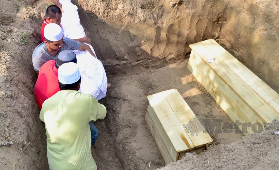 JENAZAH tiga beranak yang meninggal terkena renjatan elektrik di Sungai Buloh di kebumikan pada satu liang lahad di Tanah Perkuburan Islam Kampung Lembah. FOTO/FATHIL ASRI.