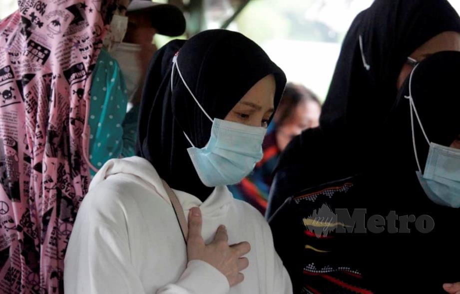 IBU arwah Sandra Dianne, Nor Syakinah (baju putih) tidak dapat menahan sebak pada pengebumian anaknya di Tanah Perkuburan Islam Kampung Kauluan, Tuaran. FOTO RECQUEAL RAIMI