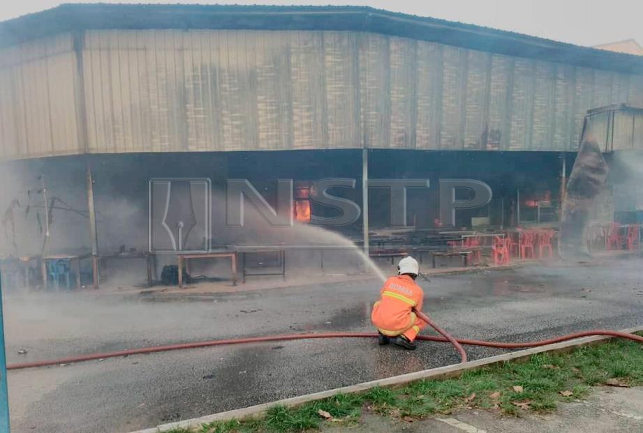 ANGGOTA bomba berusaha memadam kebakaran enam kedai makan di bandar Chukai, pagi semalam. FOTO Rosli Ilham.