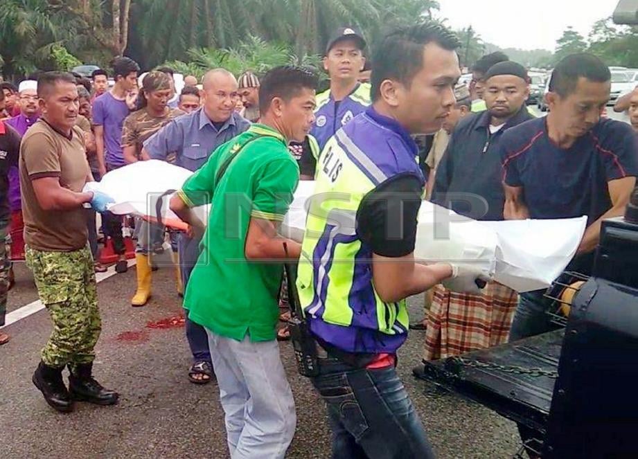 ANGGOTA polis bersama penduduk kampung mengangkat mayat Muhammad Haziq Irfan selepas kemalangan di Kilometer 23, Jalan Dungun-Bukit Besi, dekat Kampung Padang Pulut, Dungun, hari ini. FOTO Rosli Ilham.