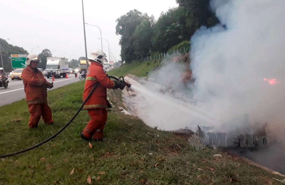 ANGGOTA bomba memadam kebakaran van yang menyebabkan dua mangsa rentung dalam kemalangan di KM 262.3 PLUS arah utara dekat Seremban, Rabu lalu. FOTO ihsan bomba. 