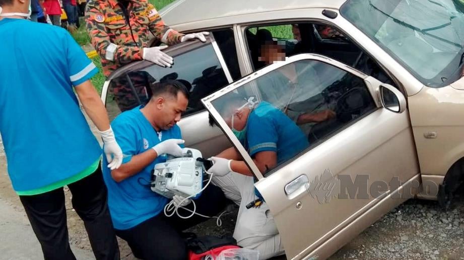PASUKAN keselamatan membantu mangsa yang terperangkap dalam kereta selepas terbabit kemalangan. FOTO Junaidi Ladjana