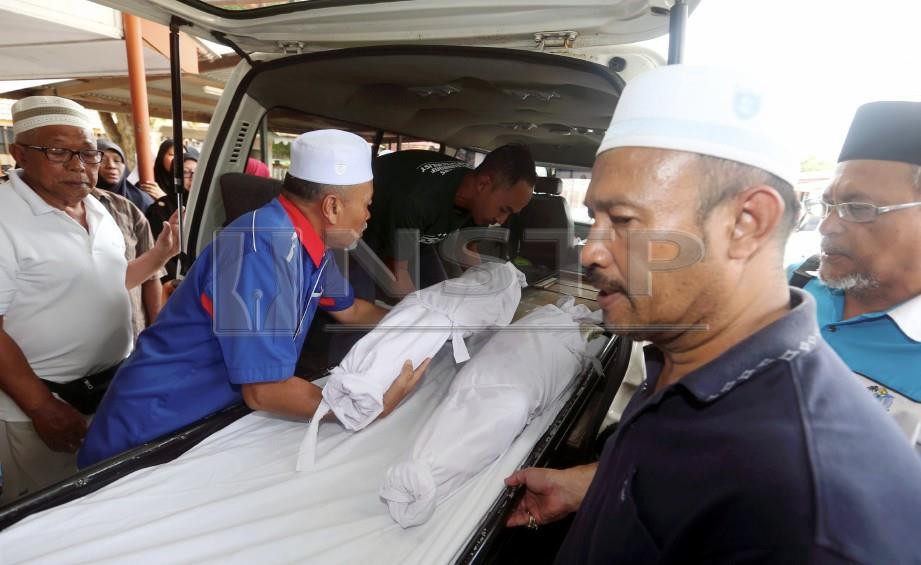 AHLI keluarga meletakkan jenazah Muhammad Adli Mohd Firdaus, 6, (dua dari kanan) dan adik perempuannya, Nur Dalili Mohd Firdaus, 4, ke dalam van jenazah untuk dibawa dari Unit Forensik Hospital Kota Tinggi bagi dikebumikan di Kluang. FOTO Hairul Anuar Rahim
