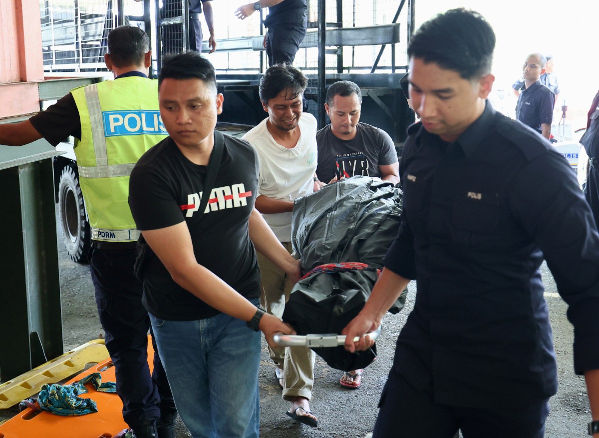 ANGGOTA polis mengangkat mayat mangsa tragedi kepala air sebaik tiba di Jabatan Forensik, Hospital Lahad Datu hari ini. FOTO Bernama 