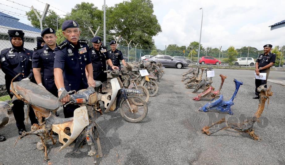 ZAINUDDIN (tengah) menunjukkan sebahagian 24 rangka motosikal curi yang ditemui dalam sungai di Kampung Batu 15,  Relong, Mukim Bukit Raya. 