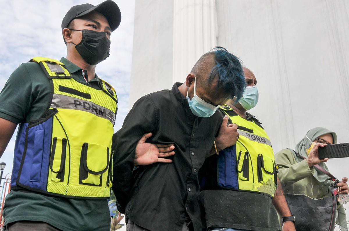 Mohd Syawalludin dibawa anggota polis untuk didakwa di Mahkamah Majistret Kajang, Kajang. FOTO AIZUDDIN SAAD