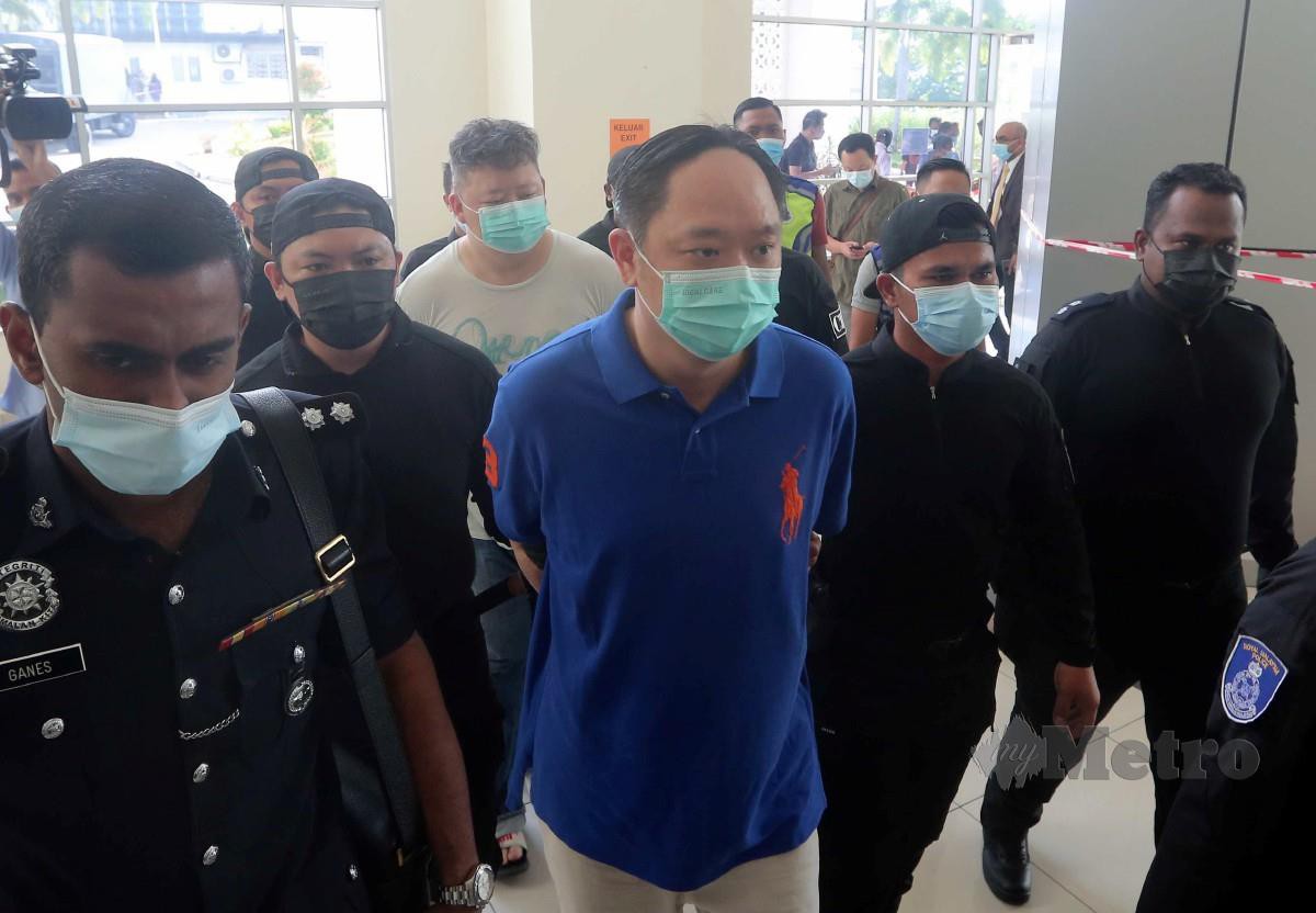 Chee Yang (depan) dan pembantu peribadinya (belakang) diiringi pegawai polis untuk didakwa ke Mahkamah Majistret, Klang. FOTO Muhd Asyraf Sawal