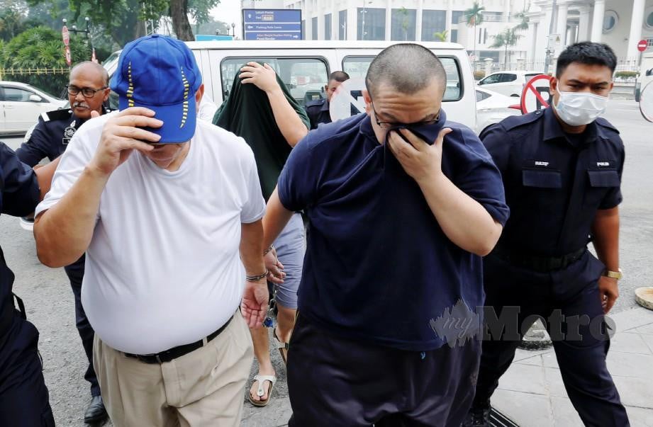 POLIS membawa suspek kes sindiket MyKad palsu dipercayai didalangi pegawai kanan JPN Pulau Pinang di Mahkamah Sesyen Georgetown. FOTO RAMDZAN MASIAM
