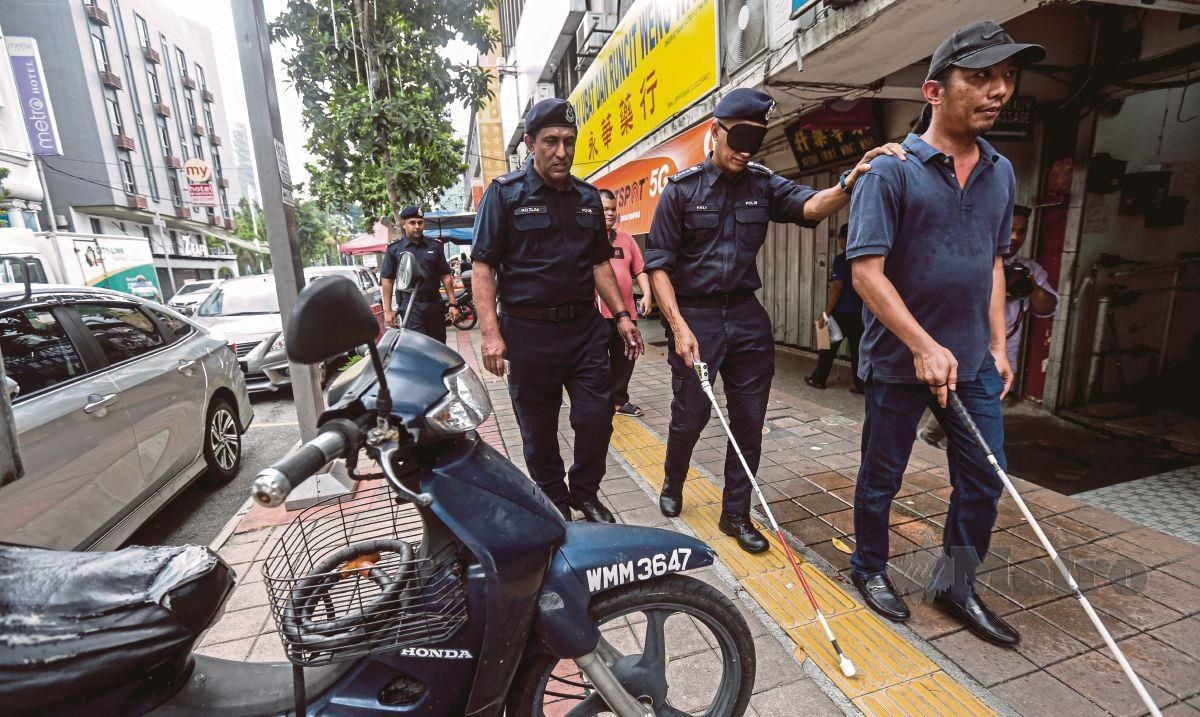 Shuhaily Mohd Zain menyantuni warga OKU penglihatan di sekitar jalan Jalan Tun Sambathan pada progran santuni warga OKU penglihatan bersama Ketua Polis Kuala Lumpur. FOTO HAZREEN MOHAMAD