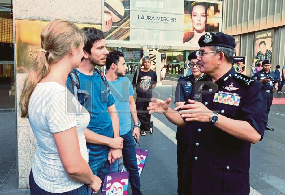 MAZLAN (kanan) beramah mesra dengan pelancong asing yang ditemui pada Program Kepolisan Berprofil Tinggi di pusat beli-belah sekitar Jalan Bukit Bintang, Kuala Lumpur, hari ini.
