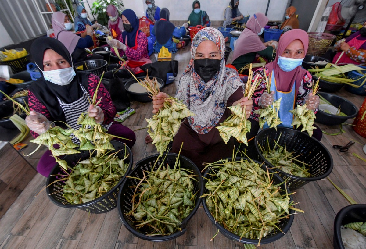 ZARINA (tengah) menunjukkan sebahagian ketupat palas yang siap dibungkus untuk dijual kepada pelanggannya. FOTO Bernama 