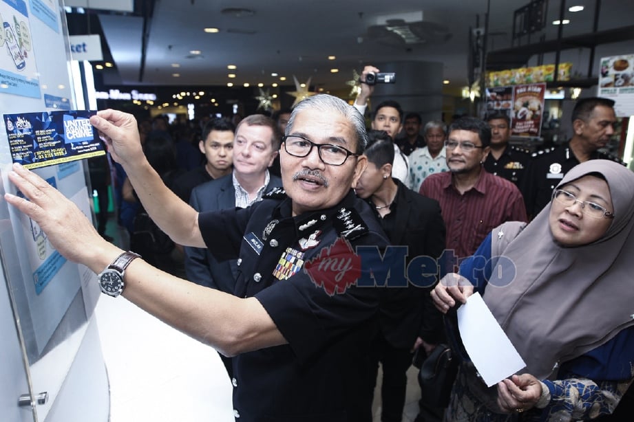 Ketua Polis Kuala Lumpur, Datuk Mazlan Lazim menampal pelekat Talian Aduan Polis ketika melawat Plaza Low Yatt sempena program Pencegahan Jenayah “Be Smart- Don’t Be A Victim Of Cybercrime”, semalam. - Foto