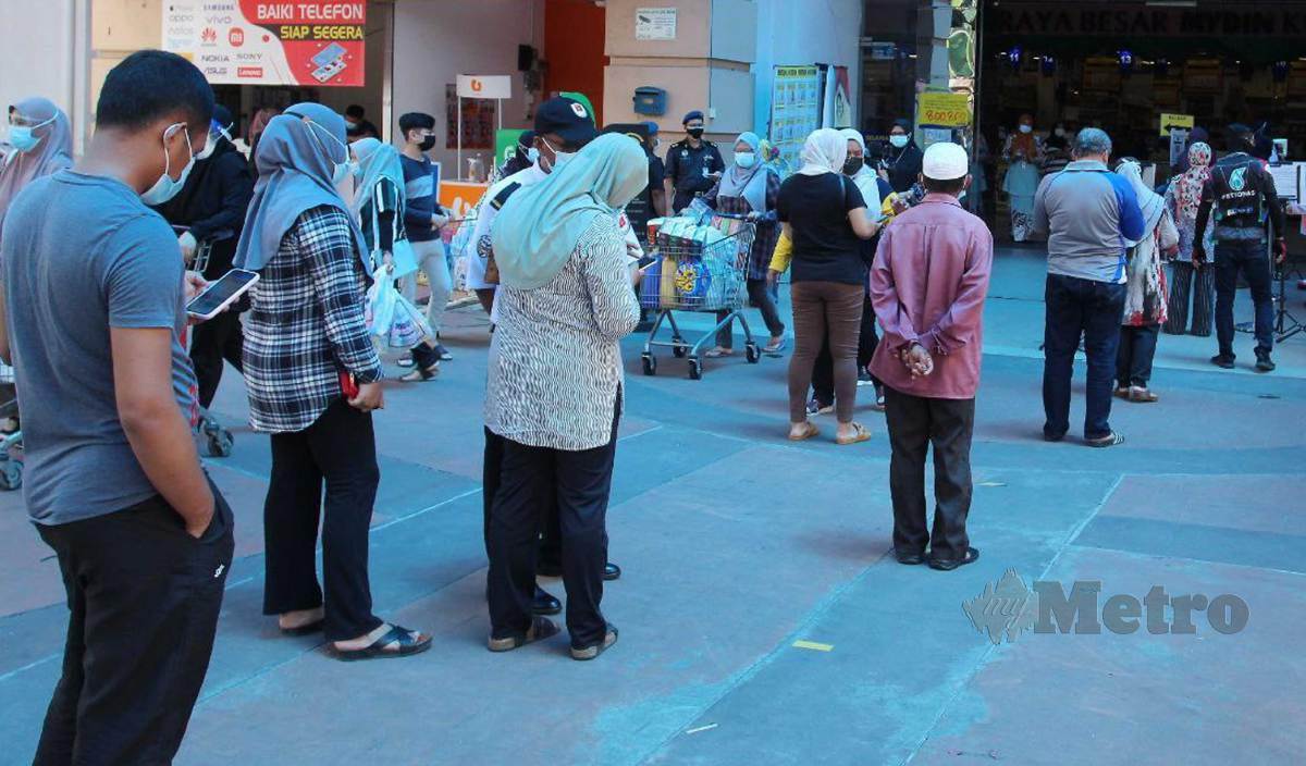 ORANG ramai beratur untuk memasuki pasar raya untuk membeli barangan keperluan.  FOTO Nik Abdullah Nik Omar