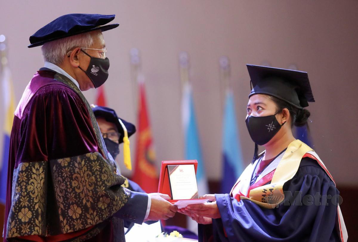 Mahdzir (kiri) menyampaikan Anugerah Khas Kecemerlangan Diploma Orang Asli kepada graduan Diploma Pendidikan Awal Kanak-kanak, Arisna Dahlan pada Majlis Konvokesyen Kolej Ketengah Kali Ke-3 di Universiti Malaysia Terengganu (UMT). FOTO GHAZALI KORI