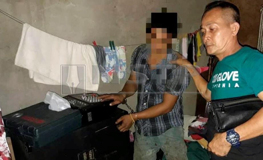 ANGGOTA polis menahan suspek dan merampas barangan curi sebagai bahan bukti di kediamannya di Jalan Sebiew, Bintulu. FOTO Erika George