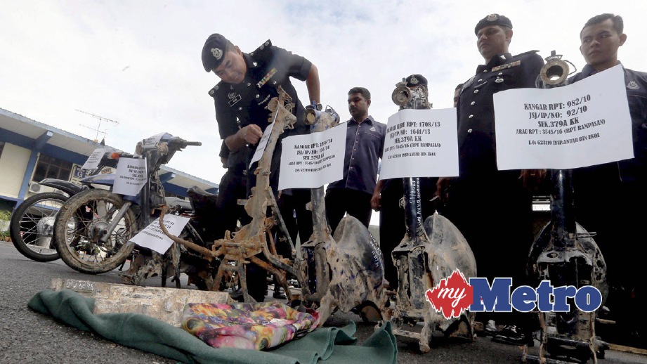 WARI (kiri) menunjukkan rangka motosikal curi yang ditemui dibuang. FOTO Eizairi Shamsudin