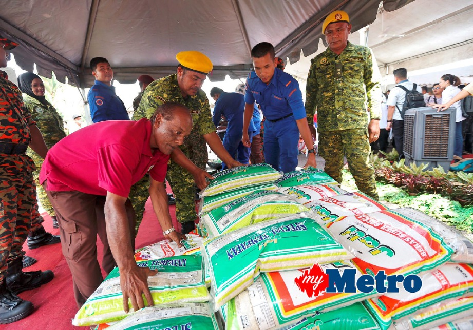 SUKARELAWAN menyusun beras untuk mangsa banjir yang disampaikan oleh Menteri Sumber Asli dan Alam Sekitar, Datuk Seri Dr Wan Junaidi Tuanku Jaafar di Pusat Pemindahan Sementara di SK Durian Mentangau. FOTO Ghazali Kori