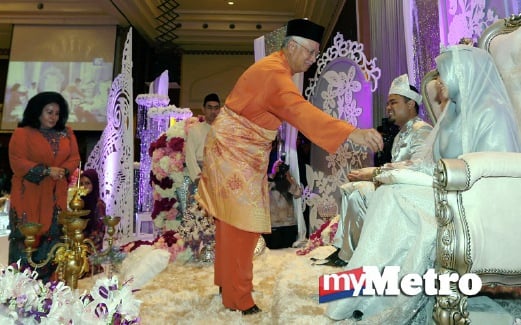 NAJIB menepung tawar kepada pengantin baru Nur Aziati (kanan) dengan suaminya  Muhammad Jamal (dua kanan) sambil diperhatikan Rosmah (kiri). FOTO Aswadi Alias