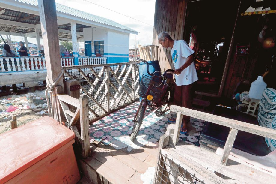 NELAYAN, Rosli Hassan memindahkan barang barang di rumahnya di Kampung Bahagia, Kuala Perlis.