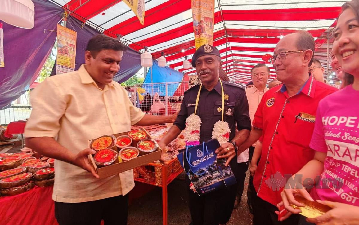 Pengusaha kuih bakul, B Balamurali menunjukkan produknya kepada Ketua Polis Johor, Komisioner M Kumar ketika mengadakan Walkabout di Bazar Taman Johor Jaya di sini petang semalam.