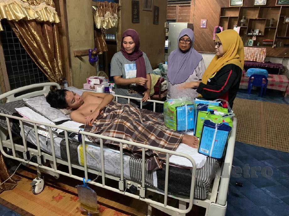SALINA (kanan) melihat keadaan Muhammad Ilman Farhan, yang terlantar yang terpaksa dijaga ibunya (kiri) bersama neneknya dirumahnya di Kampung Gedang, Terachi, Kuala Pilah. FOTO MOHD KHIDIR ZAKARIA