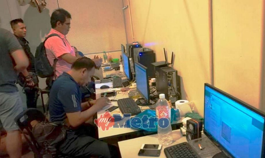 ANGGOTA polis dari Bahagian Anti Maksiat, Perjudian dan Kongsi Gelap (D7) IPK Kedah memeriksa komputer yang digunakan oleh sindiket judi online dalam serbuan di Taman Berangan. Foto STR/OMAR OSMAN