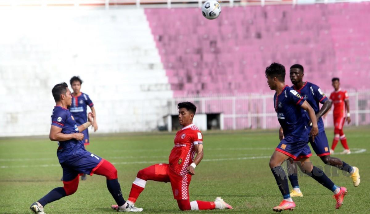 PEMAIN Kelantan FC,  Muhammad Haziq Mohd Subri  (baju merah) menanduk bola sambil diasak pemain lawan pada perlawanan Liga Perdana di Stadium Muhammad IV, Kota Bharu. FOTO NIK ABDULLAH NIK OMAR