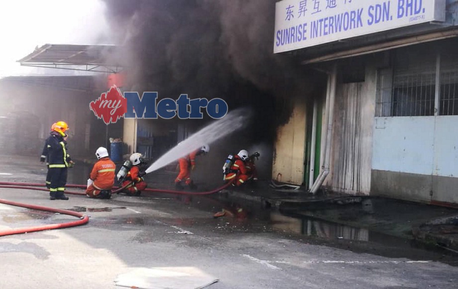 ANGGOTA Bomba memadamkan kebakaran di salah satu lot bangunan syarikat minyak dan gas di Saguking Warehouse, Jalan Patau-Patau, Labuan. FOTO Bernama