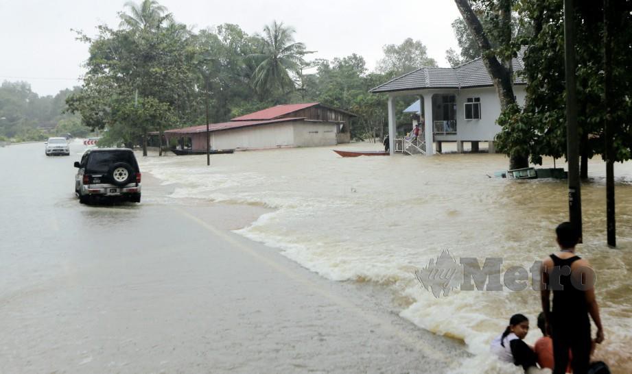 KAWASAN kampung di Jalan lama Pasir Mas-Jeram Perdah di Rantau Panjang tidak boleh dilalui kenderaan ringan selepas ditenggelami air sedalam 1.5 meter pada 12 tengah hari semalam. FOTO Syamsi Suhaimi
