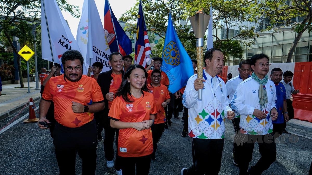 SARUN (dua dari kanan) bersama Hannah (tiga dari kiri) memulakan larian membawa obor sempena Sukan Sea Kemboja di Menara KBS, hari ini. FOTO HAZREEN MOHAMAD