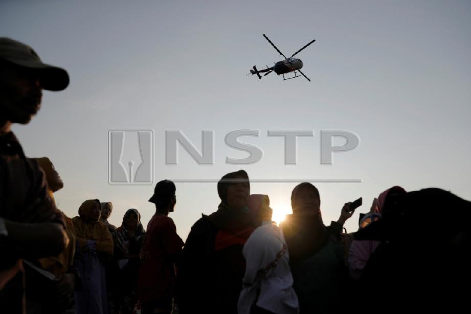 Helikopter menuju ke kawasan nahas. FOTO Reuters