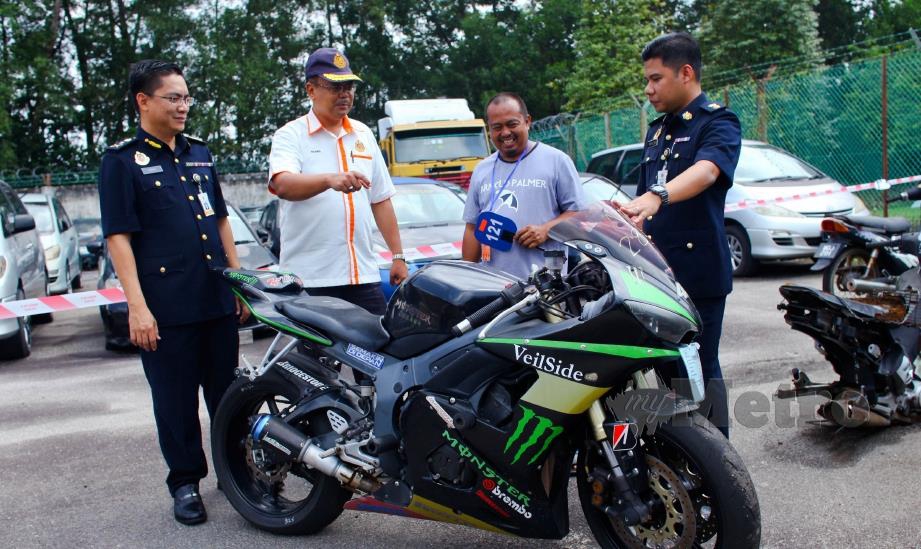 KHAIRUL Anwar (dua dari kiri) beramah mesra dengan Abdullah Husin (dua dari kanan) yang berjaya membida motosikal berkuasa tinggi Yamaha YZF-R6 dengan harga RM15,000 pada hari lelongan awam JPJ Negeri Sembilan di Seremban, hari ini. FOTO Adzlan Sidek.