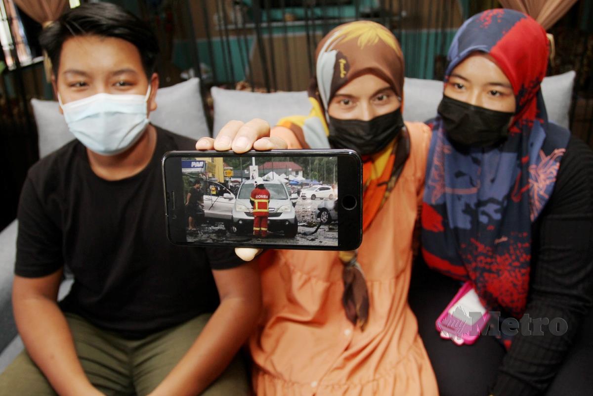 NOOR Aslinda (tengah) bersama Nur Anis (kanan) Muhammad Aiman menunjukkan SUV Honda CRV mereka yang rosak akibat letupan. FOTO NIK ABDULLAH NIK OMAR