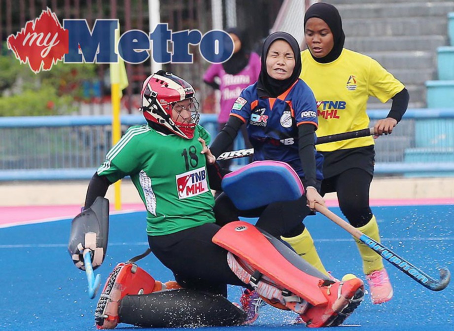 PENJAGA gol Penang Juniors, Siti Nur Aisyah Hamidi menendang bola ketika diasak pemain Blue Warriors (PDRM), Nur Iman Shahiera Bedrul Hisham (tengah). FOTO/ OWEE AH CHUN 