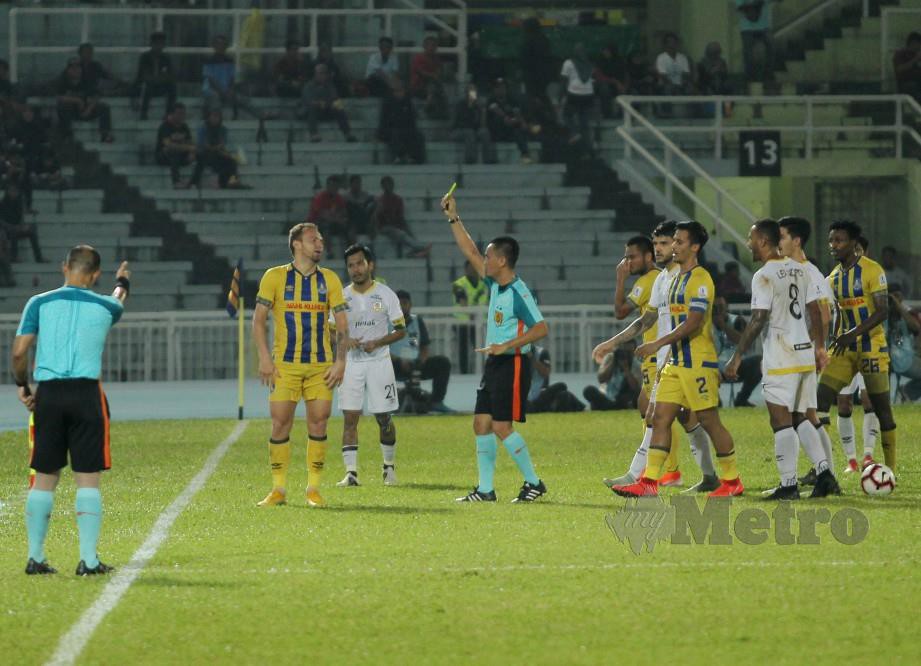 PEMAIN  Pahang, Jose Eduardo (kiri) dilayangkan kad kuning oleh pengadil ketika menentang Perak di Stadium Darul Makmur.  