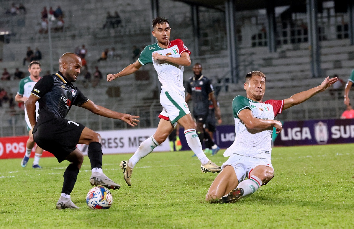 Pemain PDRM FC Fadi Mahmoud Awad Saleh cuba mengelecek pemain pertahanan Kuching City FC  pada saingan Liga Super di Stadium Negeri hari ini.-Foto Bernama