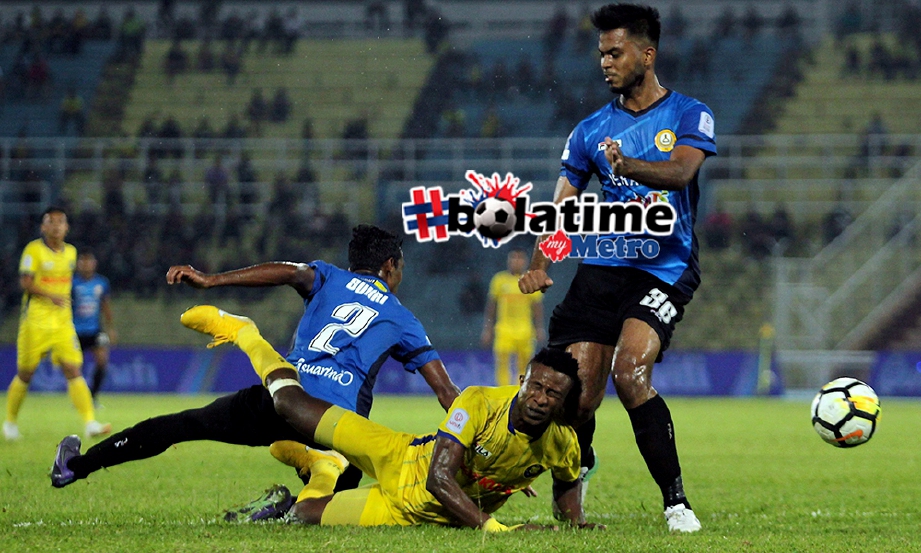 PEMAIN Pahang, Mohmadou Sumareh (tengah) diasak pemain PKNP FC, Ahmad sukri Hamid (kiri) pada saingan Liga Super 2018 di Stadium Darul Makmur. FOTO Farizul Hafiz Awang