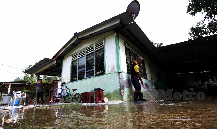 PENDUDUK membersihkan rumah yang terjejas akibat banjir di Kampung Sabak Aur, Muar, Johor. FOTO IQMAL HAQIM ROSMAN