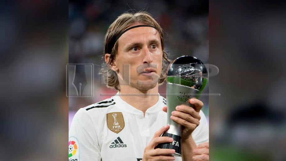 Luka Modric bersama trofi pemain terbaik FIFA. FOTO AFP 