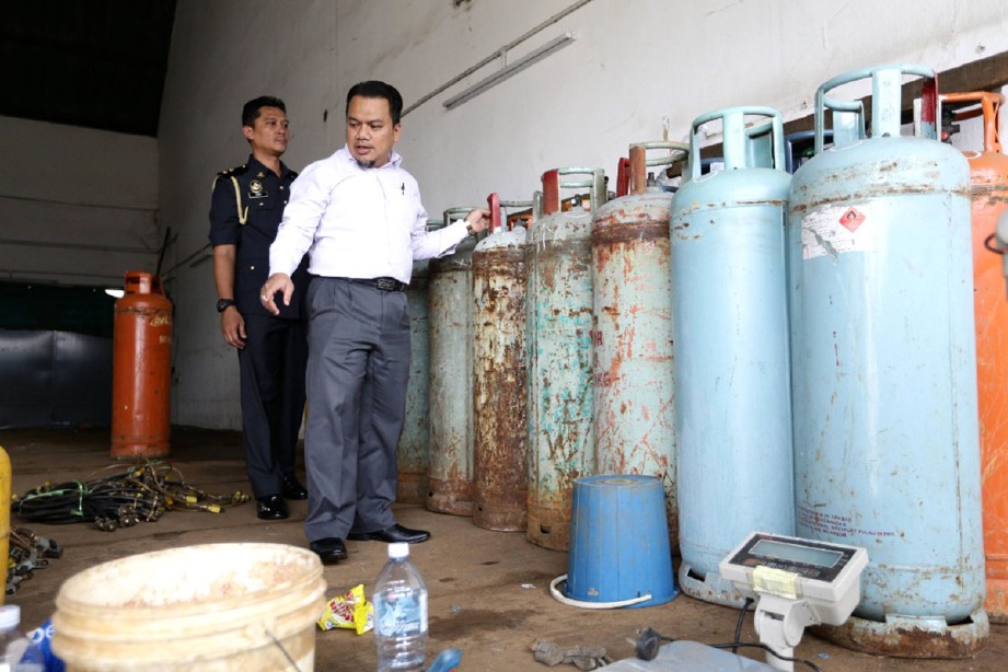 PENGARAH Kementerian Perdagangan Dalam Negeri dan Hal Ehwal Pengguna (KPDNHEP) Negeri Selangor, Muhamad Zikril Azan Abdullah (dua dari kiri) memeriksa tong gas LPG subsidi.