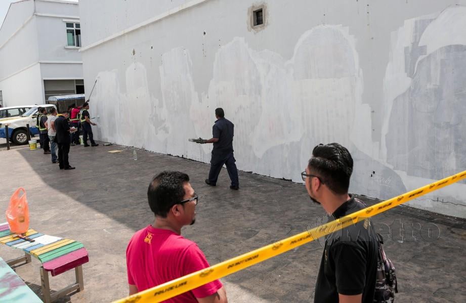 KAKITANGAN MBSA mengecat semula lukisan mural pemimpin yang diconteng oleh pihak tidak bertanggungjawab di Taman Cahaya Alam. FOTO Hazreen Mohamad