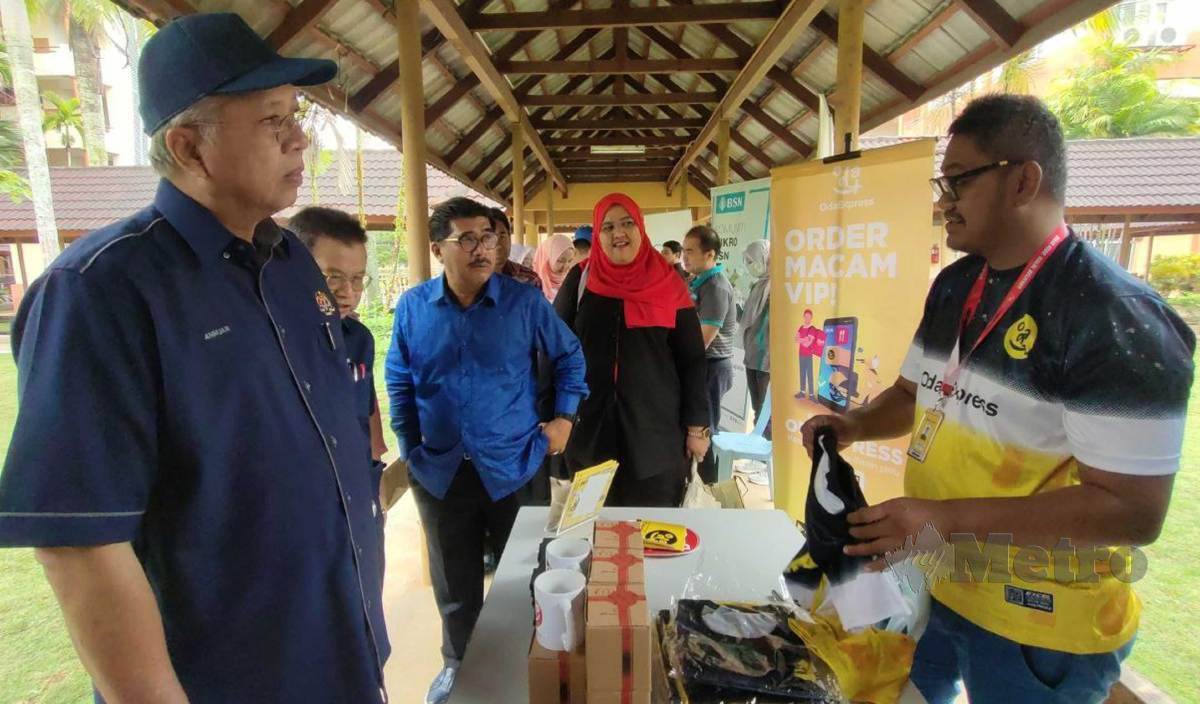 ANNUAR (kiri) melawat salah satu kiosk yang dibuka di Program Jelajah #SayaDigital Keluarga Malaysia di Politeknik Kota Bharu, Kok Lanas. FOTO Syaherah Mustafa
