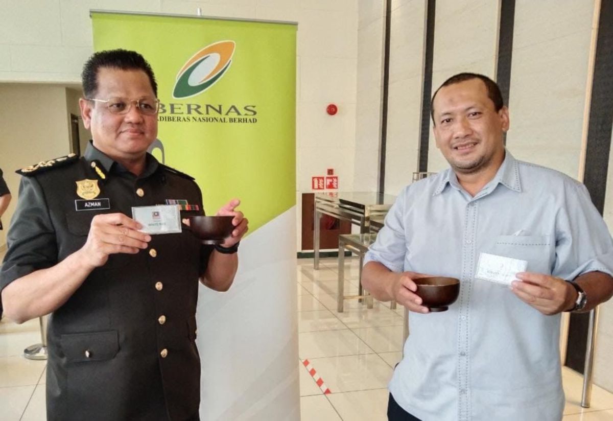 Azman (kiri) bersama Ketua Bahagian Aktiviti Huluan dan Pengurusan Konsesi Bernas,  Abdul Rahman Mohd Nasri menunjukkan beras keluaran Malaysia dan import. FOTO IHSAN MAFI