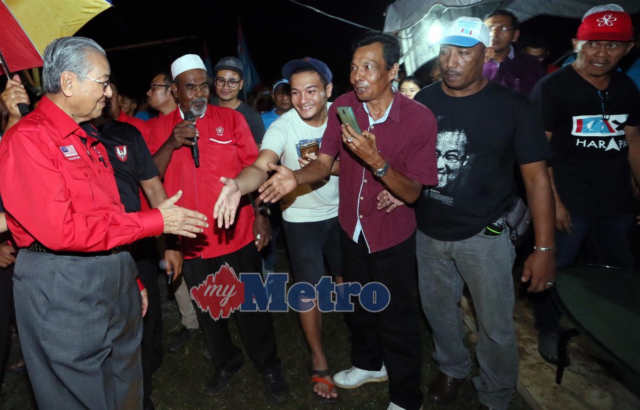 Dr Mahathir bersalam dengan orang ramai  ketika hadir pada Program Jelajah Pakatan Pembangkang di Padang Sera.  FOTO Amran Hamid