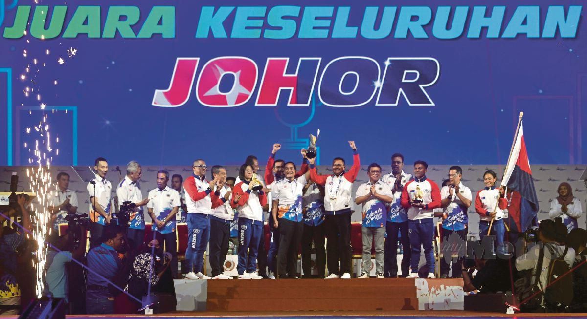 MOHAMAD Najib (enam dari kanan) menjulang trofi selepas Johor diumumkan sebagai juara keseluruhan Sukma 2022, malam tadi. FOTO MOHAMAD SHAHRIL BADRI SAALI