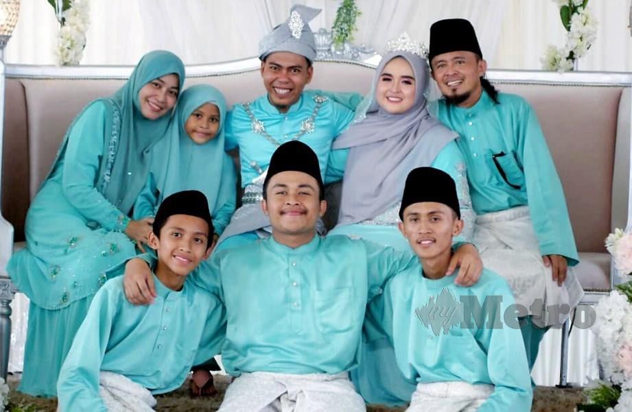 GMIE (duduk kanan) bersama keluarga meraikan perkahwinan anak perempuannya Siti Hadirah (duduk dua dari kanan) dan Muhammad Ridzzuan di Telok Panglima Garang pada 23 Mac lalu. FOTO Intan Nur Elliana Zakaria