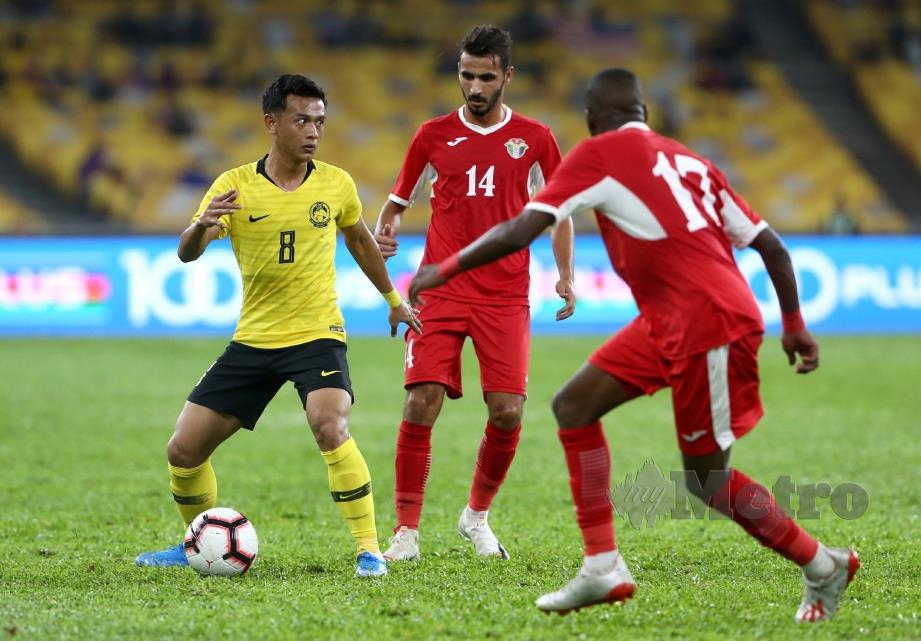 AKSI Nor Azam (kiri) mengawal bola daripada dirampas pemain Jordan ketika aksi persahabatan antarabangsa di Stadium Nasional Bukit Jalil.  
