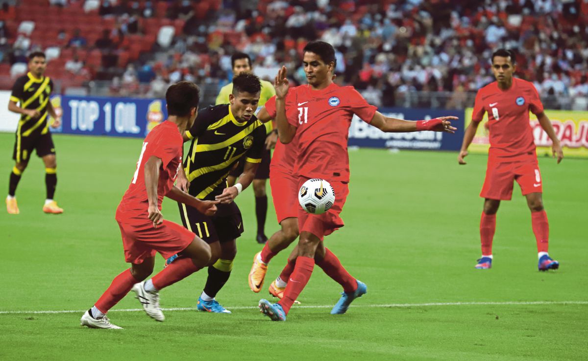 SAFAWI  Rasid diasak dua pemain Singapura. FOTO FAM