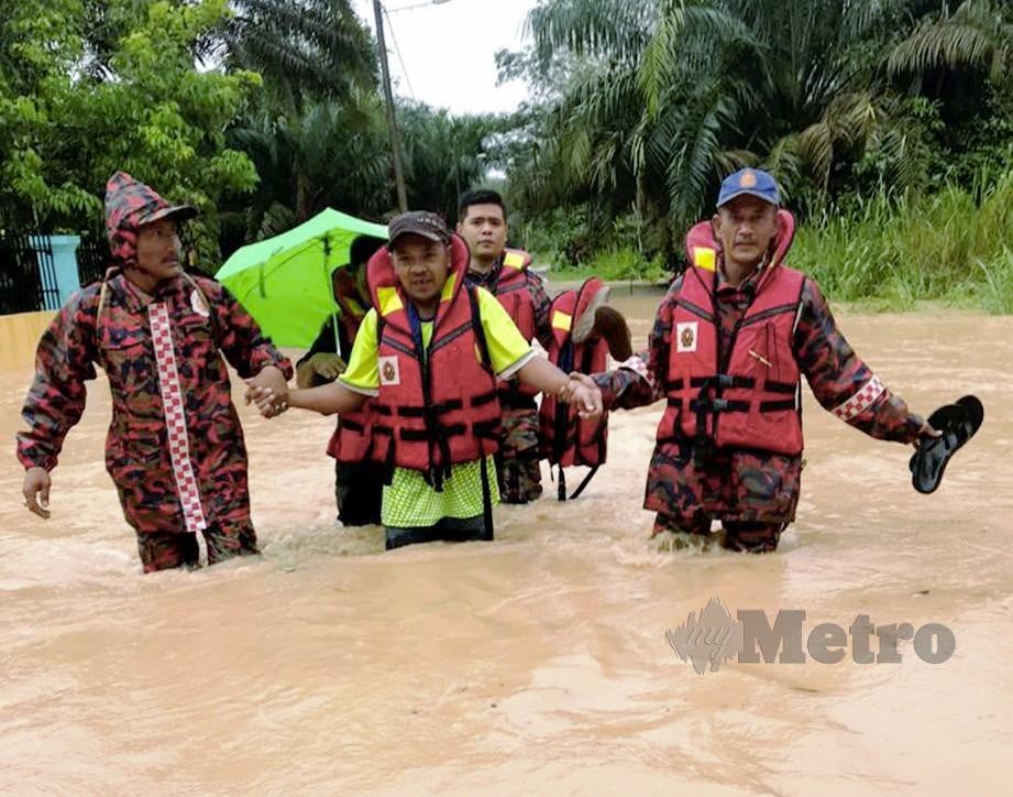 ANGGOTA bomba membantu memindahkan mangsa banjir di Labis, Segamat. FOTO Ihsan Bomba