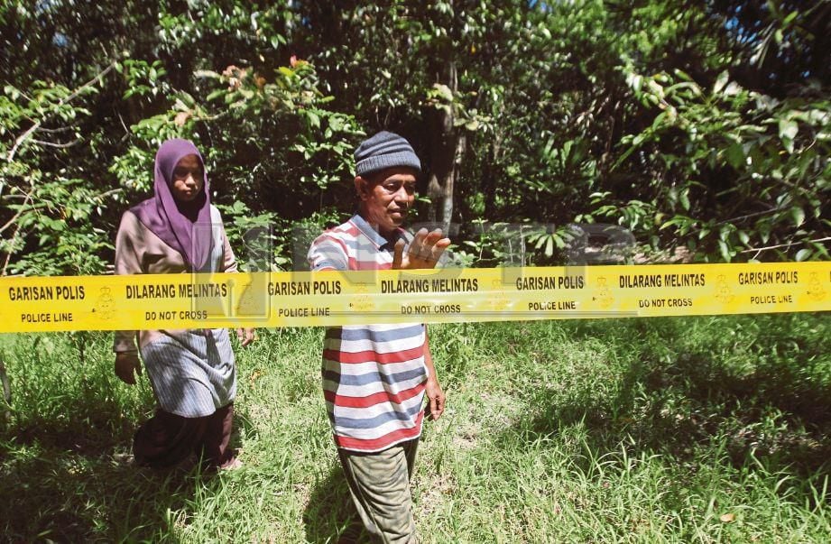 NORASIAH (kiri) bersama datuk mangsa, Abdul Manan Ahmad, 54, meninjau tempat kejadian mayat Siti Masitah ditemui dalam keadaan tragis di ladang kelapa sawit Kampung Tanjung Medang Hilir, Pekan. FOTO Muhd Asyraf Sawal.